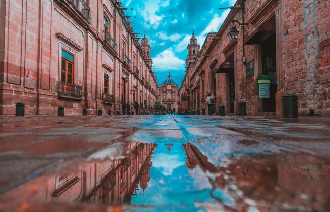 Empty alley with buildings on side under blue sky photo